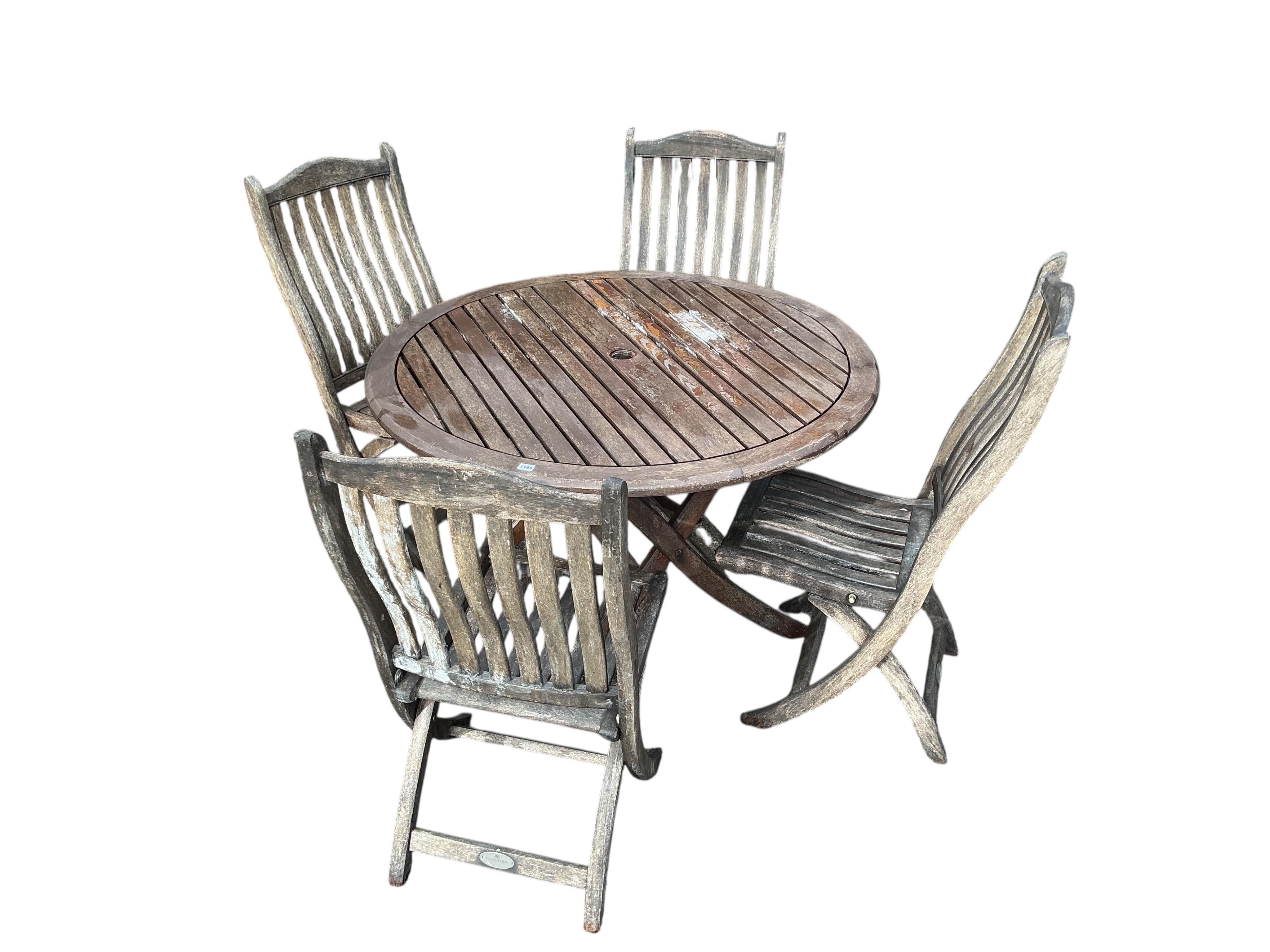 An Alexander rose folding teak garden table, diameter 120cm, height 74cm, and four chairs